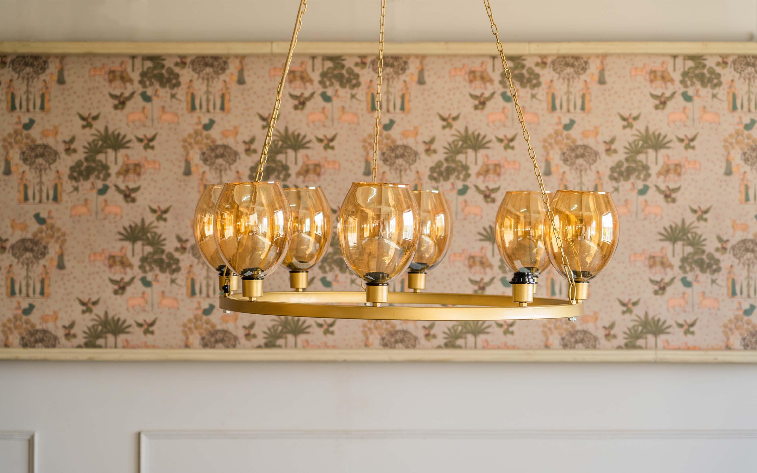 A golden-hued chandelier with multiple glass shades, providing a touch of elegance to living room ceiling lighting
