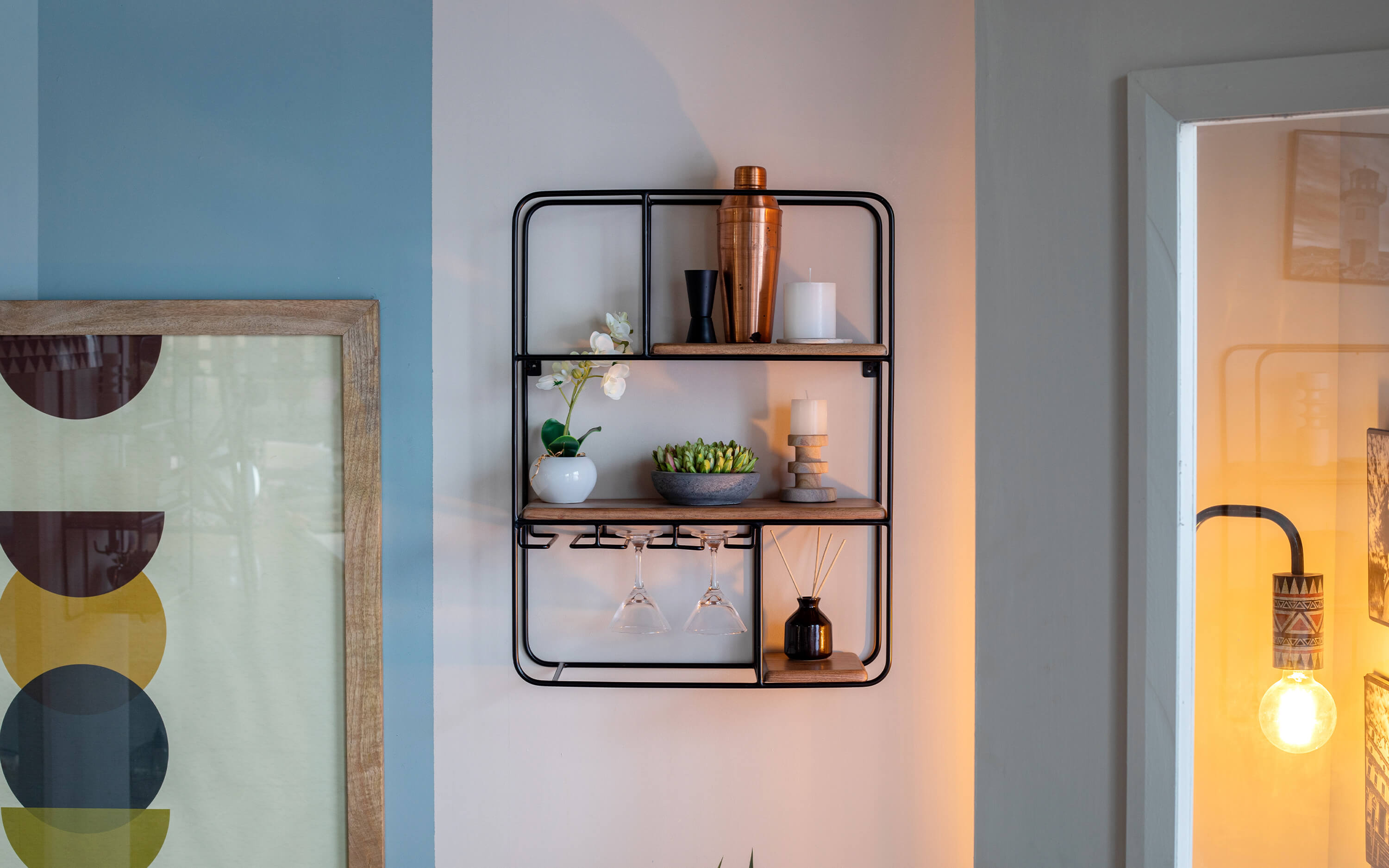 Contemporary home decor wooden shelf with metal framing on a light blue wall, enhancing the space with minimalist style.