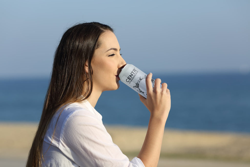 woman at the beach drinking Centr Sparkling Water