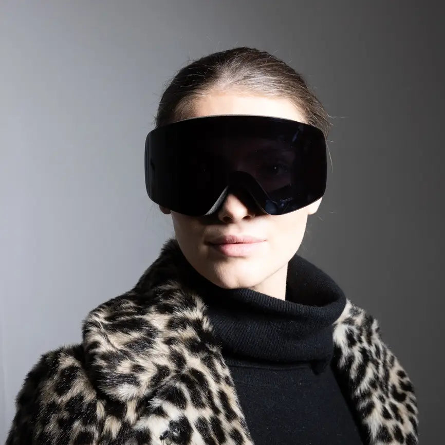 Ski goggles in black — worn by model with leopard coat, frontal view