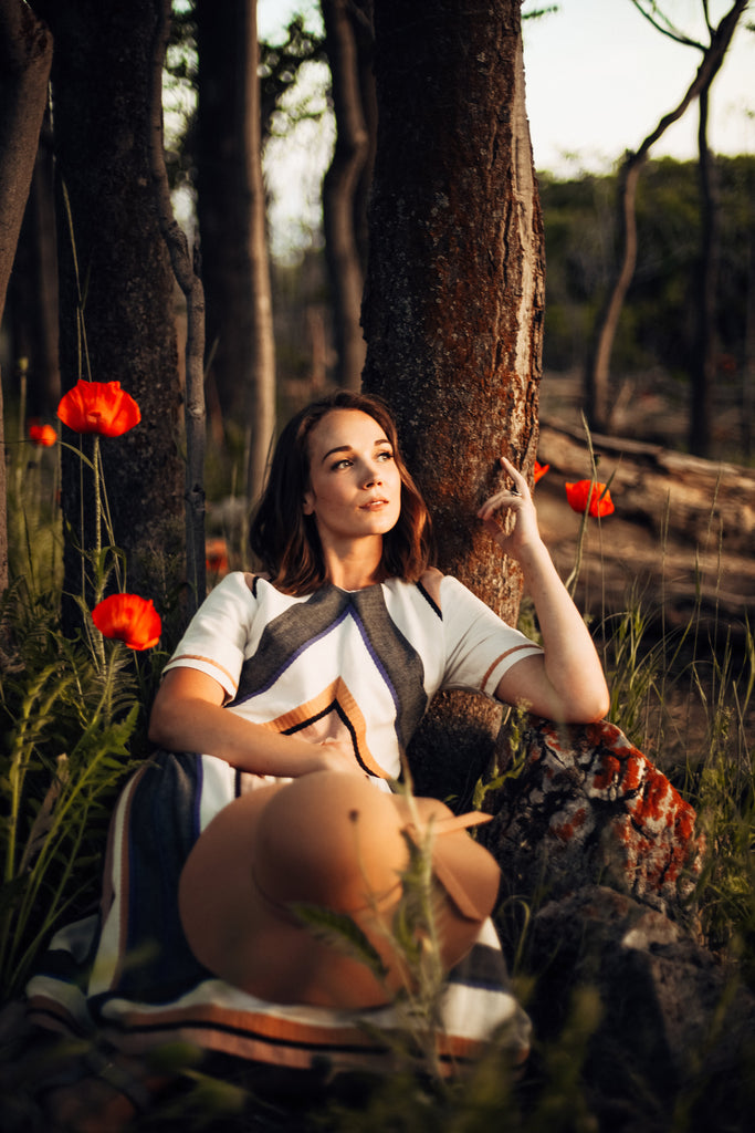piper & scoot model wearing a lovely dress while lying in a poppy field