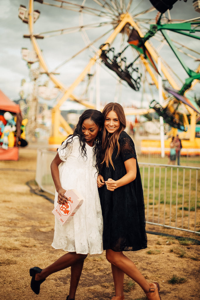 Two girls wearing the black and white Ellie dresses from Piper & Scoot