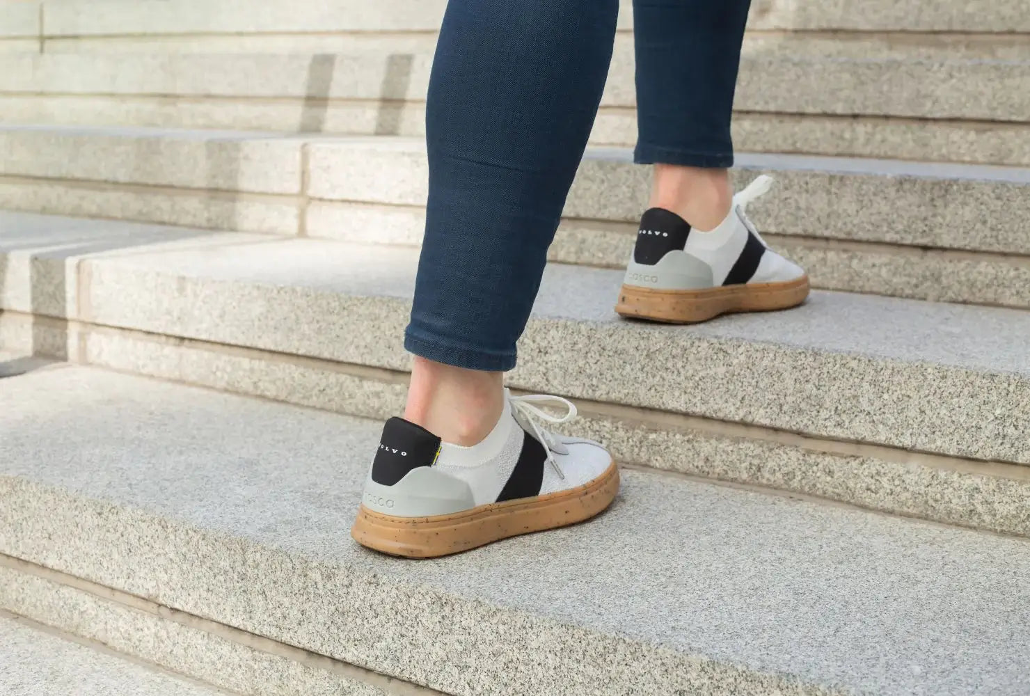 A model walking up stairs outside wearing Volvo shoes.