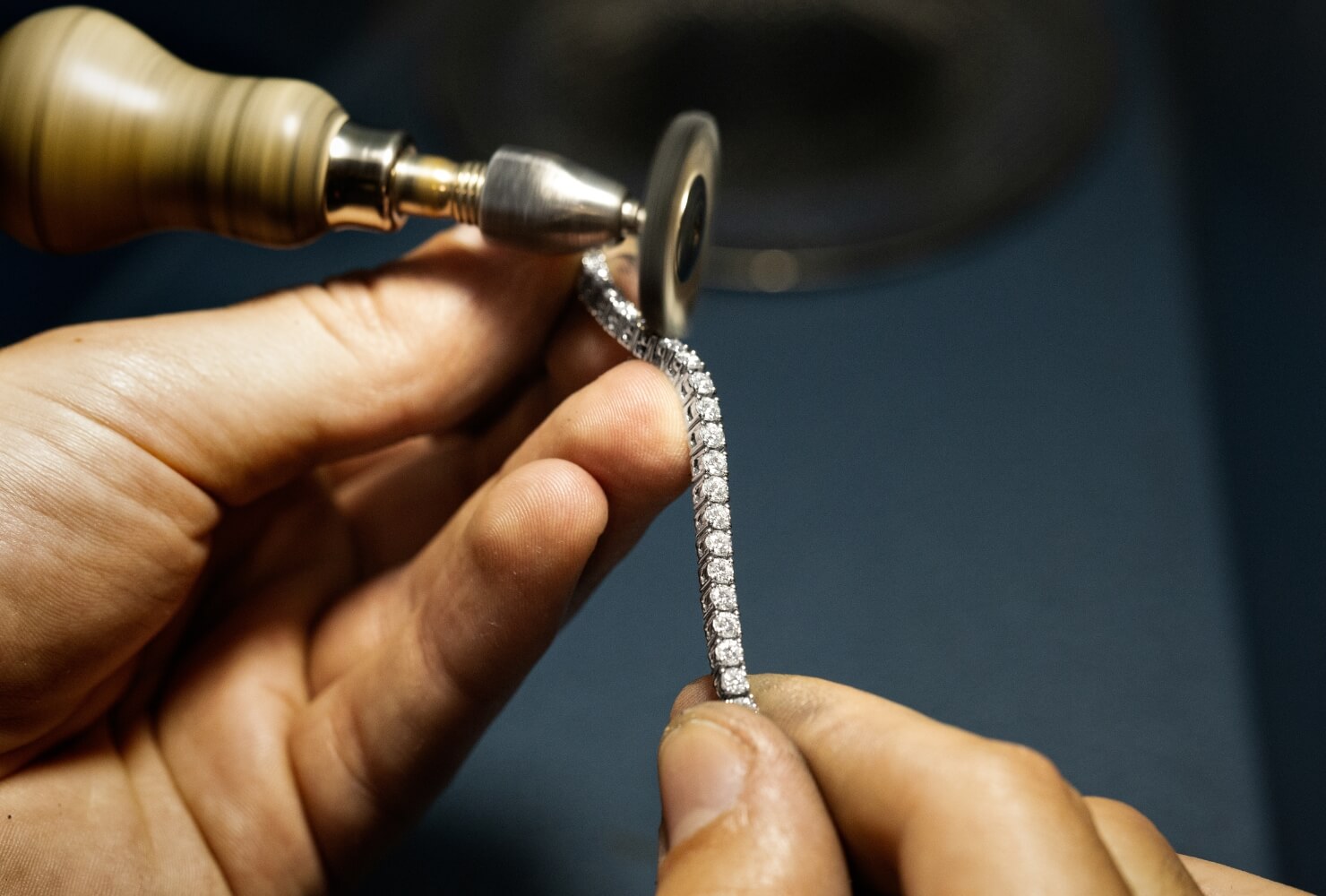 a jeweller polishing an ecksand diamond tennis bracelet 