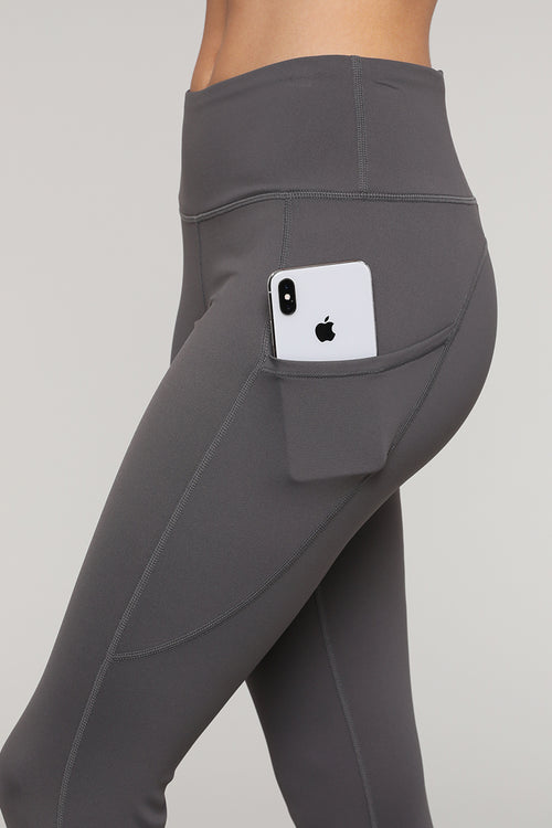 Women's Plus Size Active High Rise Capri Athletic Leggings with Pockets. •  Flattening elasticized waistband with interior pocket and back zipper  pocket • Figure sculpting skinny leg design • Exterior side pocket