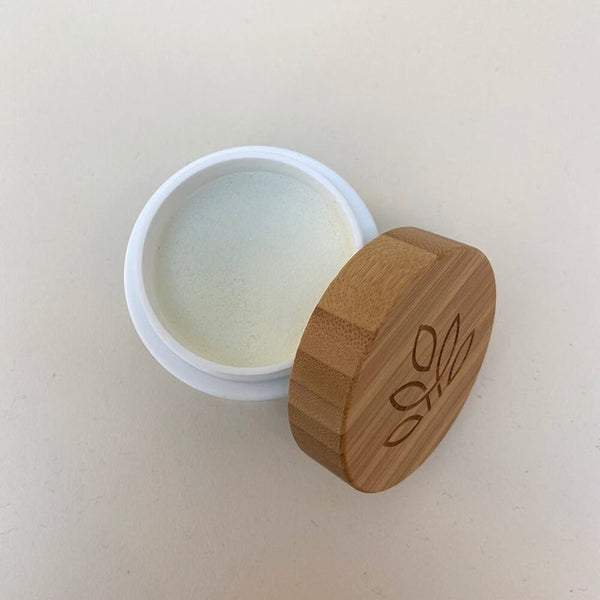 Close-up of a natural healing balm in a jar with a wooden lid on a table