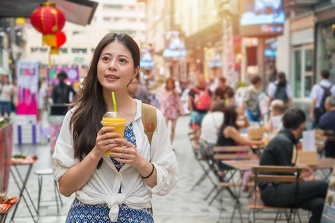 Mujer recorriendo un mercado con un Bubble Tea