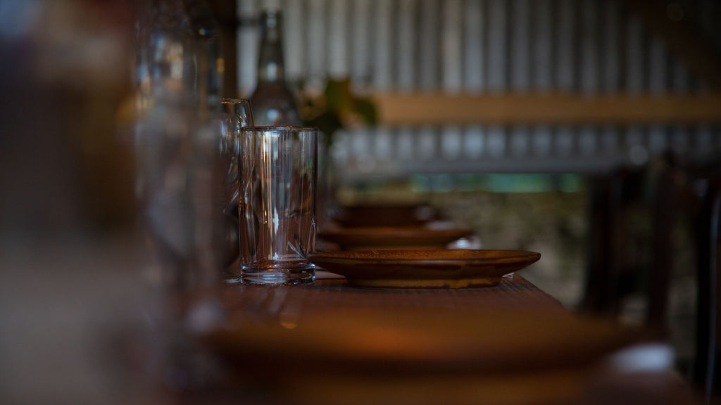 Water glasses, water bottles and plates laid up on a rustic table