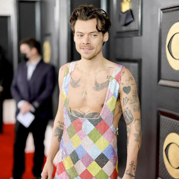 Harry Styles at the Grammys wearing checkerboard, rainbow patterned one-piece covered in Swarovski crystals