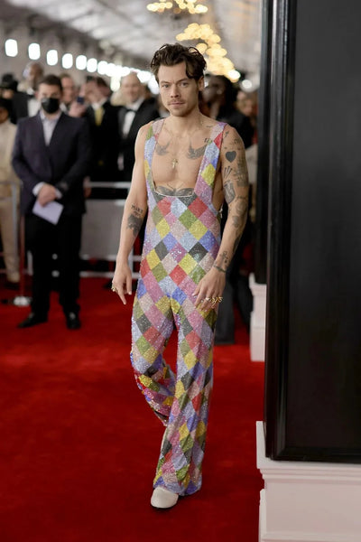 Harry Styles wearing a patterned jumpsuit with a glittering rainbow aesthetic