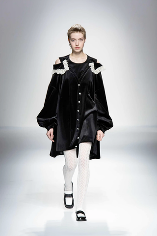 Model in black and white loose-fitting victorian essence, with cold shoulder cut puffy sleeves