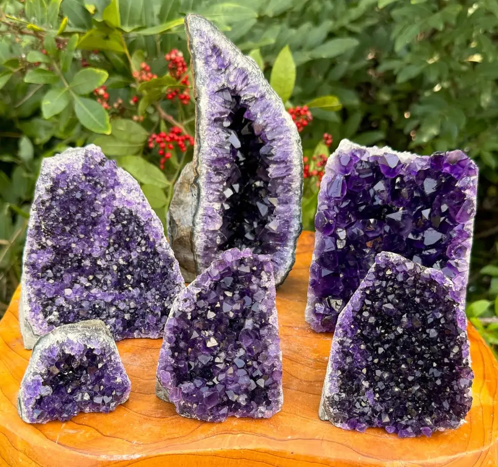 Deep purple Amethyst crystal clusters with sparkling facets on wood, powerful stones for love, calm, and relationships.