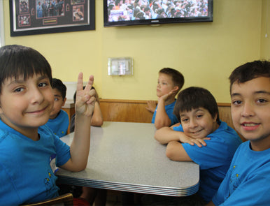 Children from FLOCK flashing the peace sign