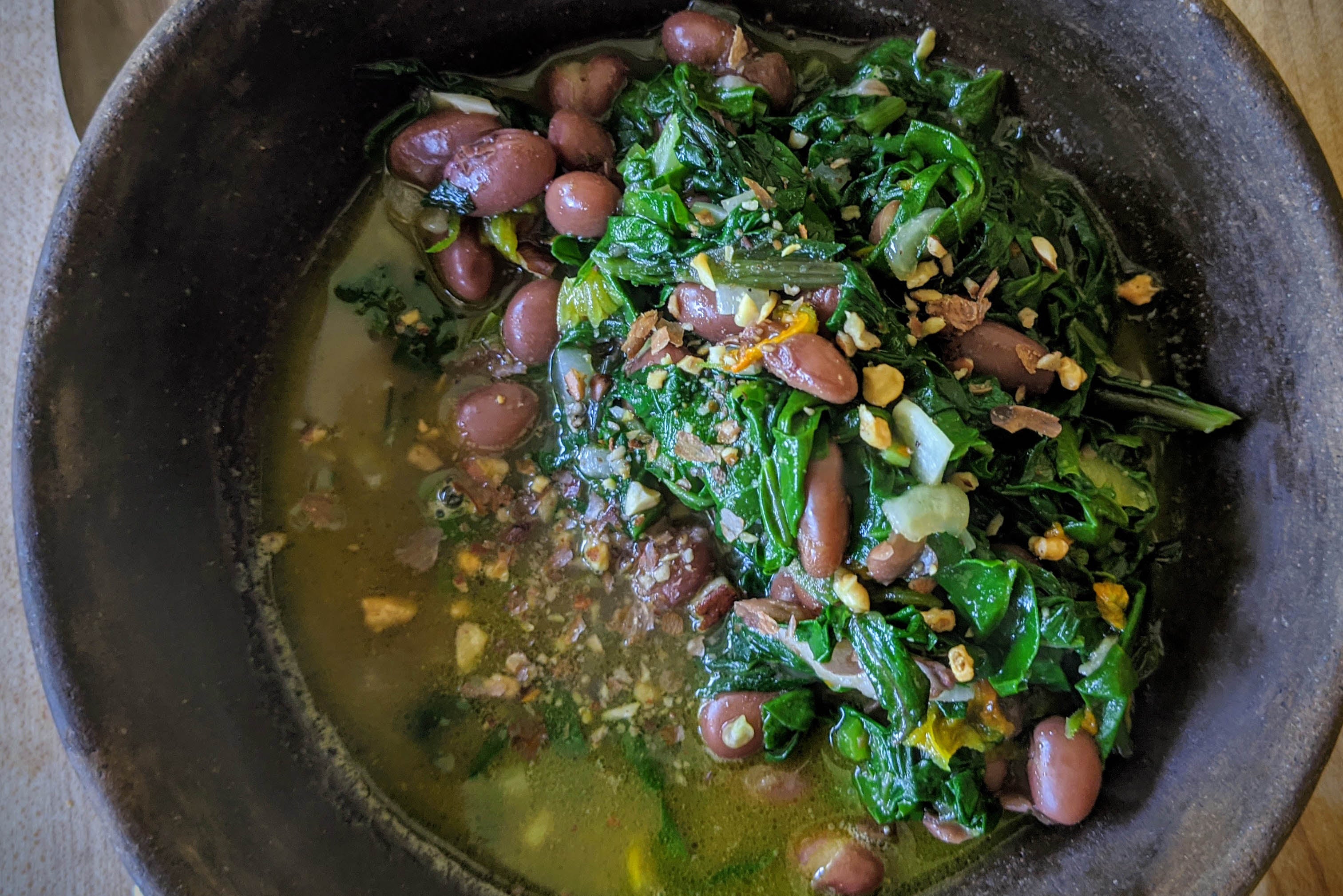 Sauteed chard with beans, bean broth, and nut dust