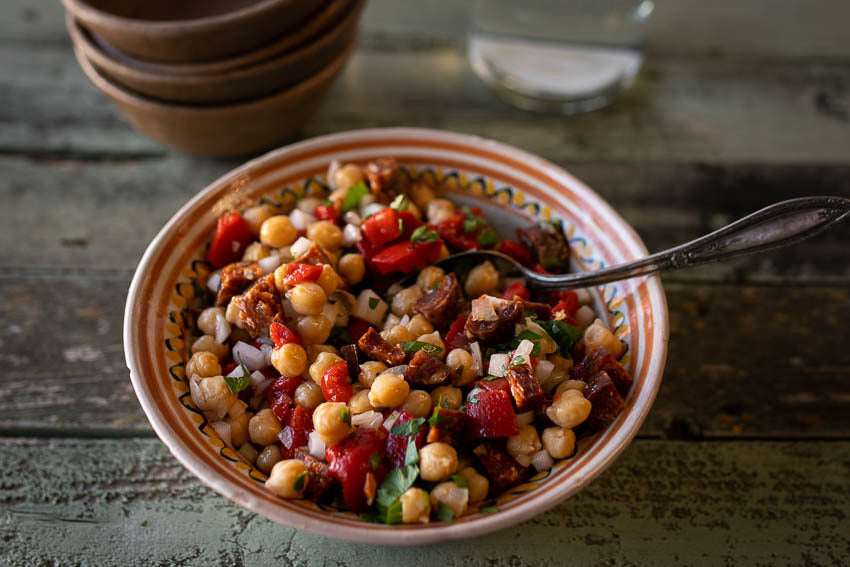 Garbanzo beans, roasted peppers, and chorizo in a serving bowl