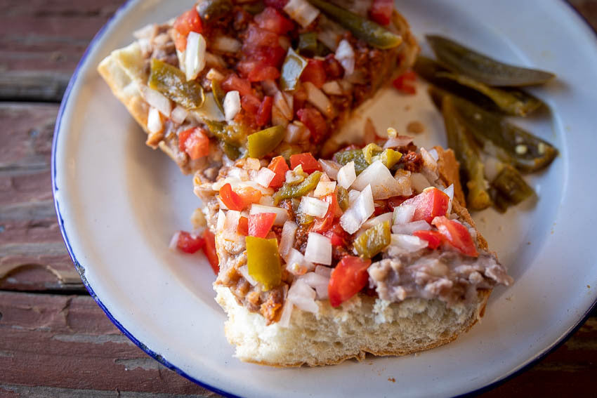 Toasted bread topped with refried beans, cheese, and fresh tomato salsa