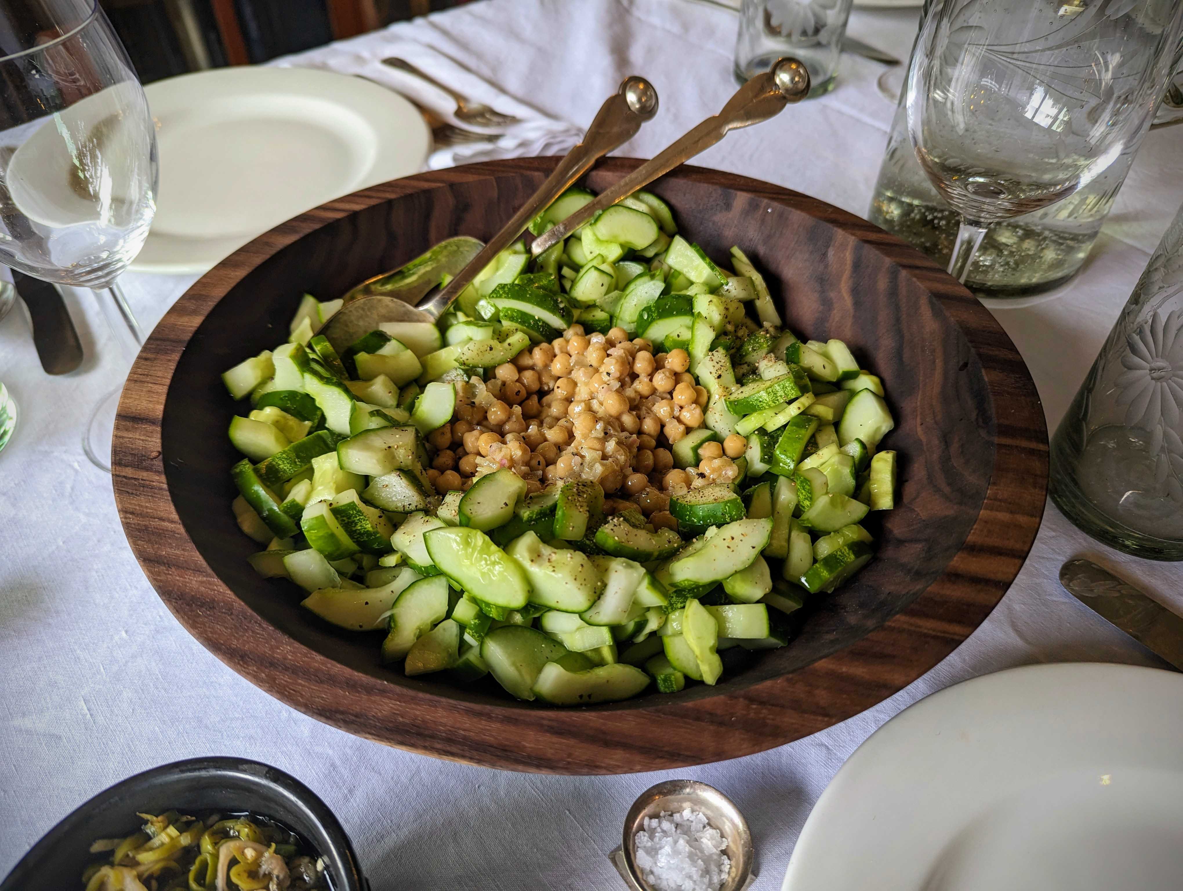 Cucumber salad with small chickpeas, in a large wooden salad bowl