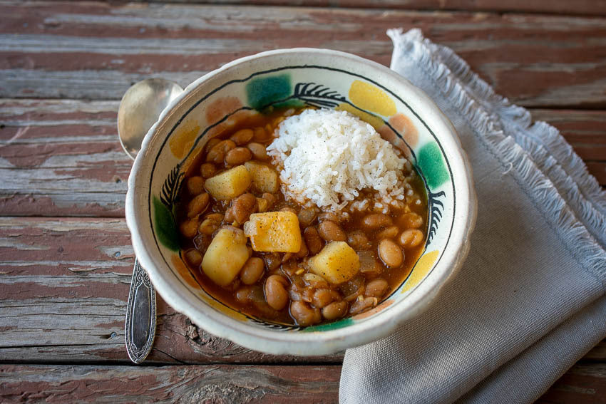 Potato and bean stew in a serving bowl with rice