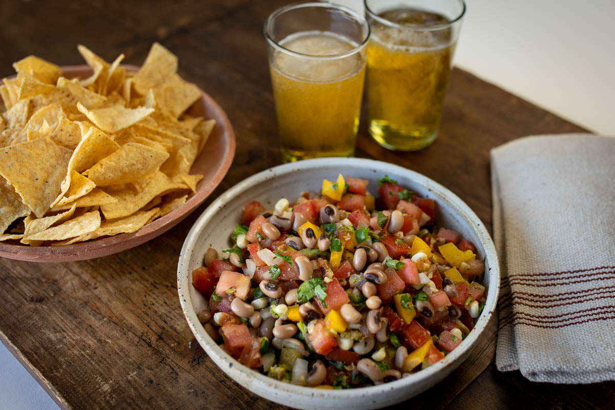 Black Eyed pea salad in a bowl, with tortilla chips on the side