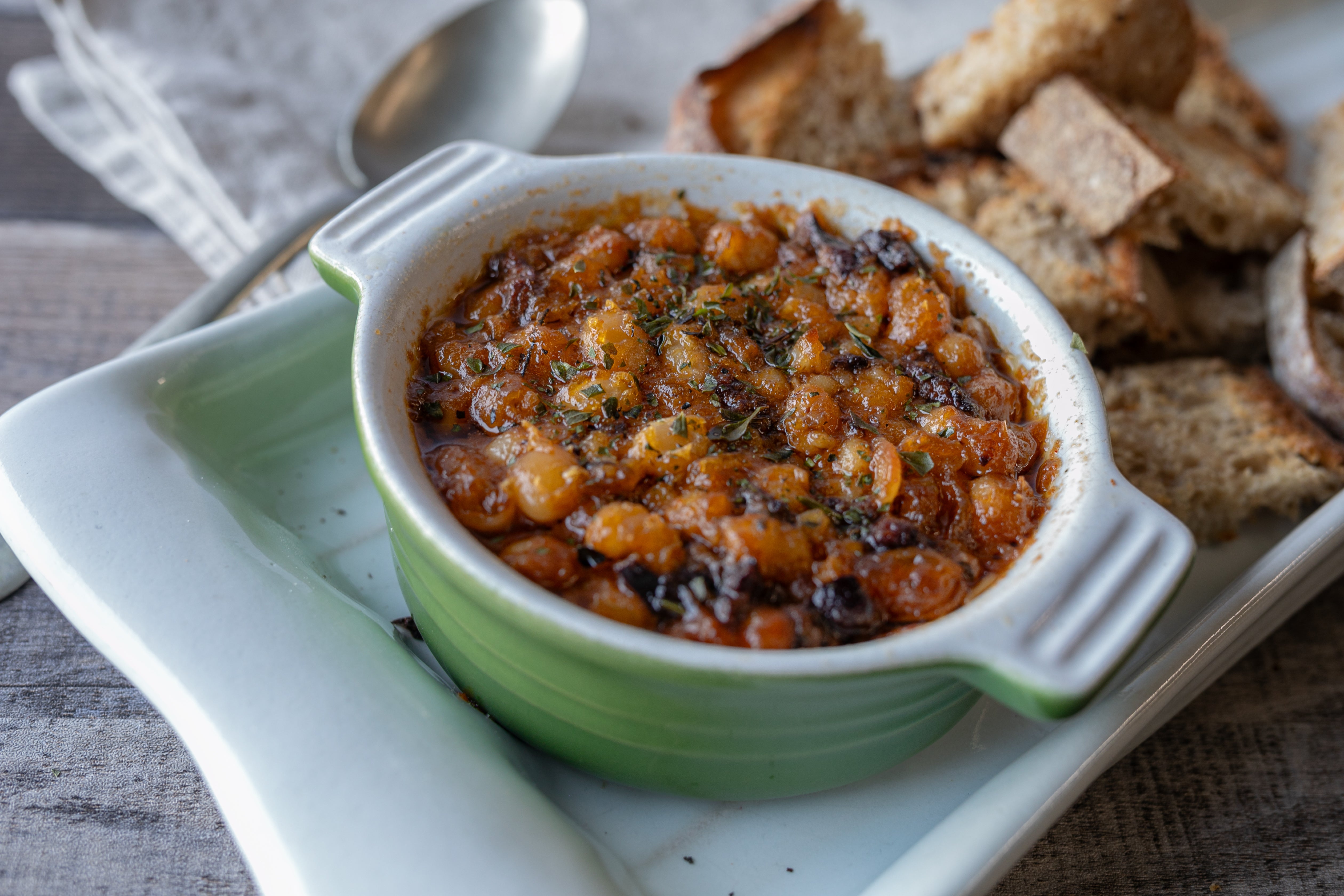 Confit beans in a dish with bread on the side