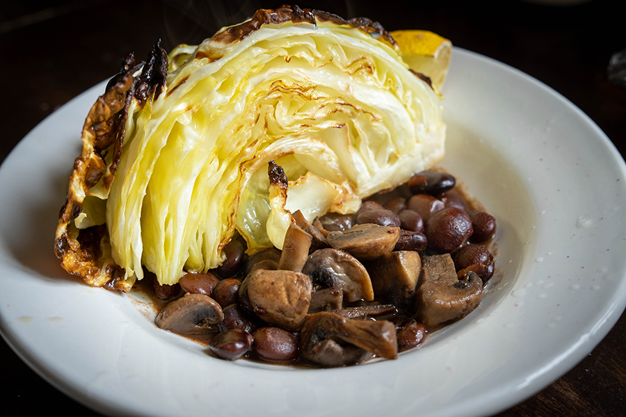 Roasted cabbage in a bowl with cooked beans and mushrooms