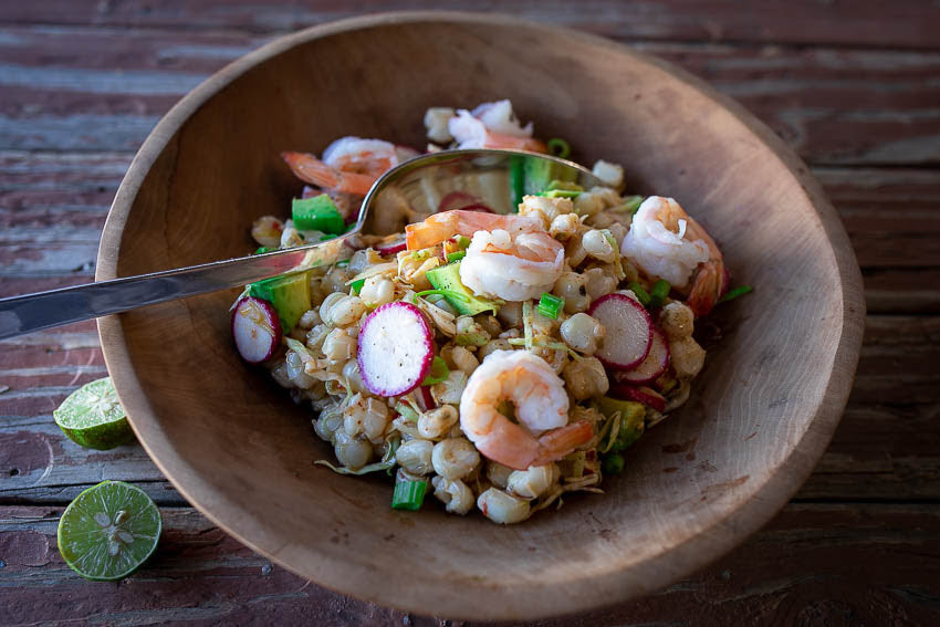 Salad of hominy, cabbage, radishes, and shrimp in a small bowl