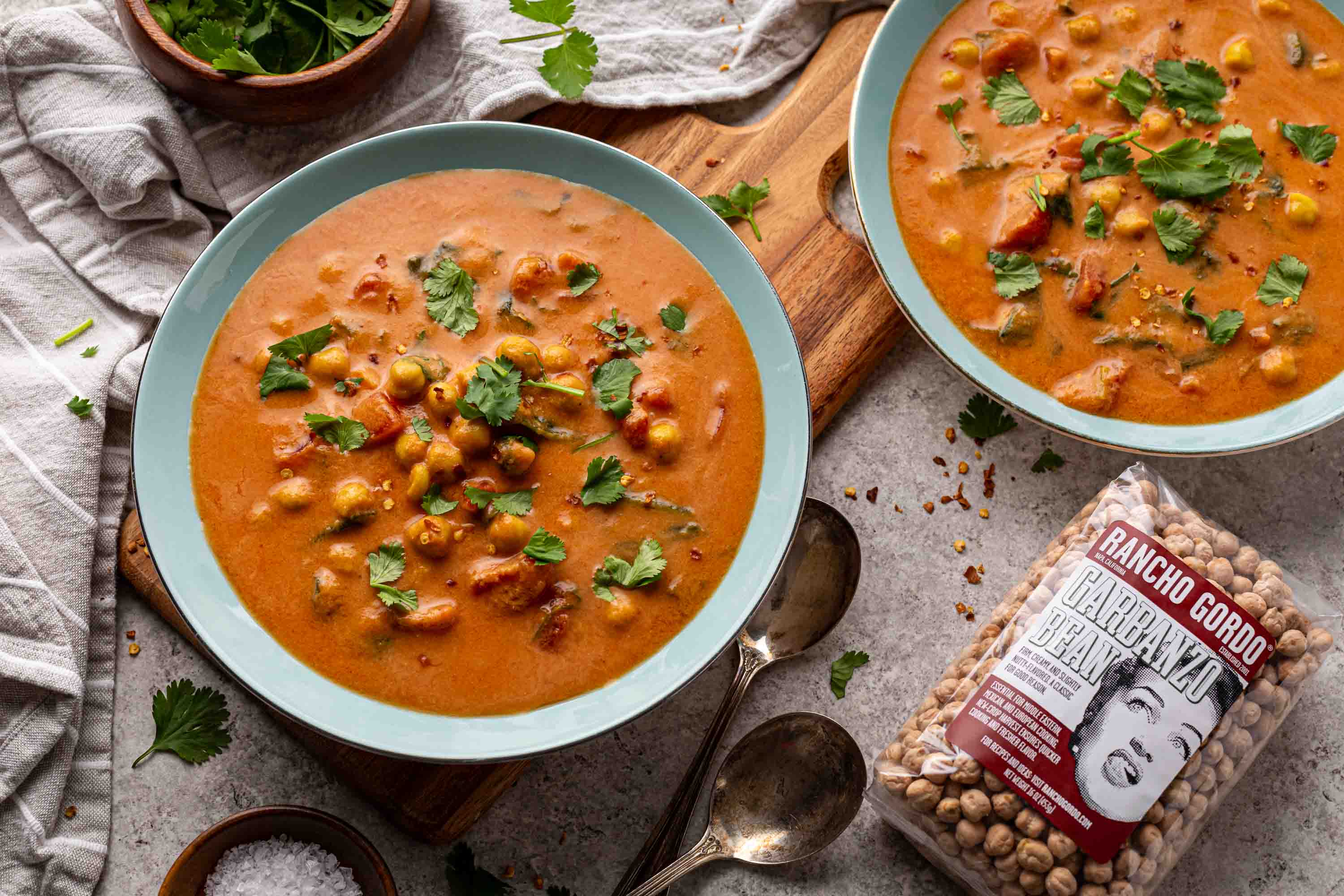 Two bowls of Chickpea Masala Tomato Soup and a bag of Rancho Gordo Garbanzo bean