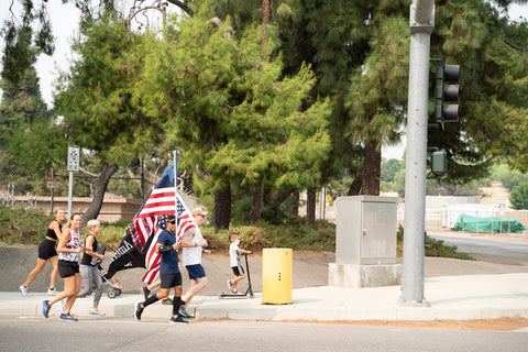 People running together holding american flags