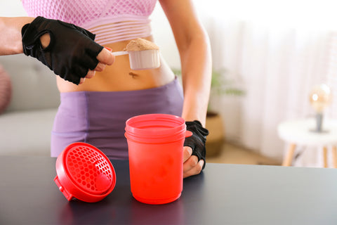 hands pouring protein powder into a cup