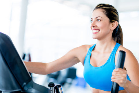 Woman smiling while on the elliptical machine