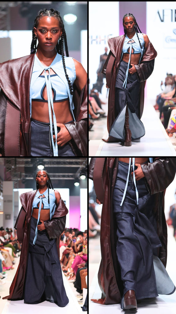 The New Left – A pale blue, two-piece cutout top, comprising a strapless bralette and light vest fastened at the neck, is paired with a dark-blue maxi-skirt. Draped over the two is a voluminous brown leather jacket with an exaggerated collar.