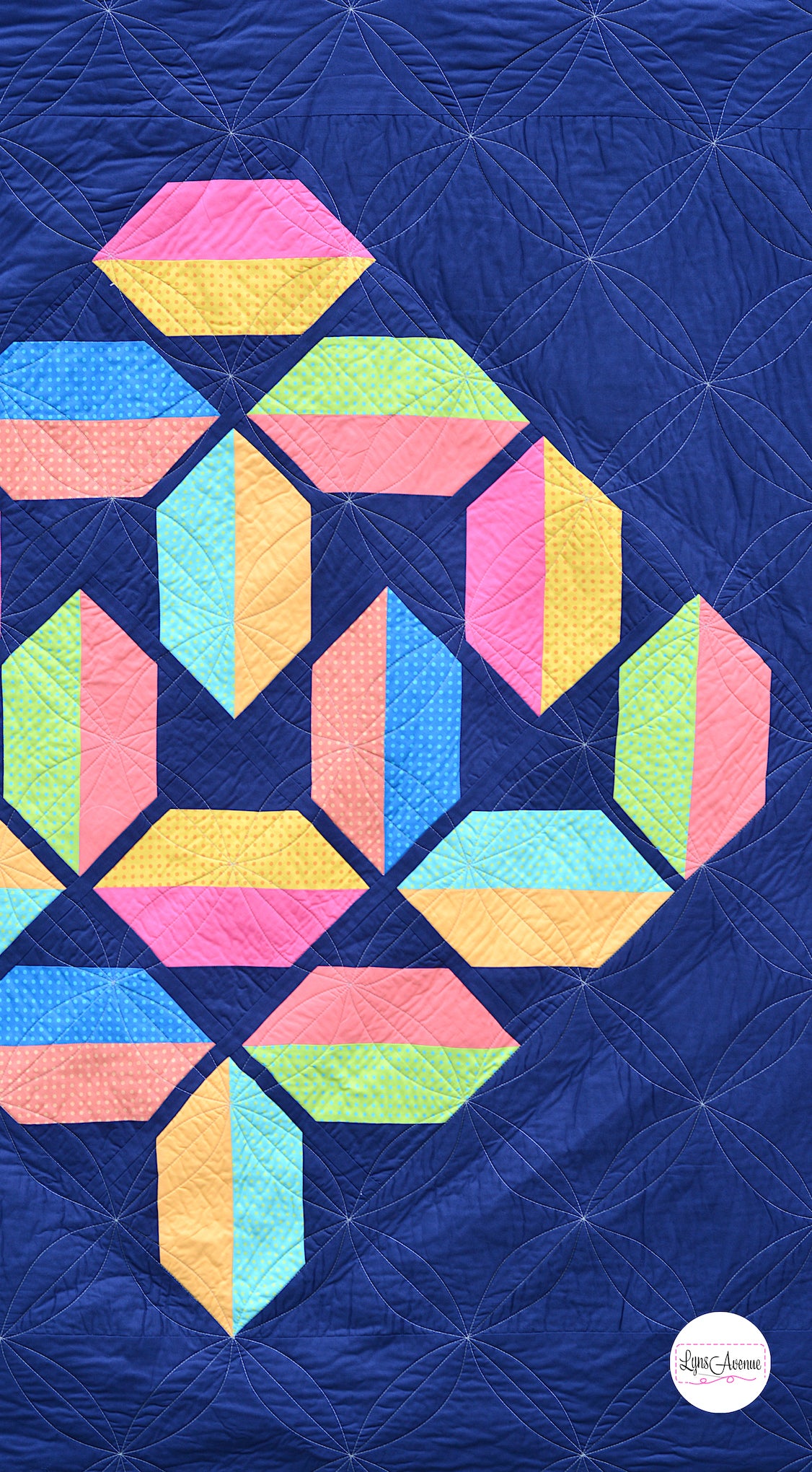 Flourishing Quilt pattern - a flower design quilt pattern in bright pink, yellow, blue and peach colour on a navy blue background