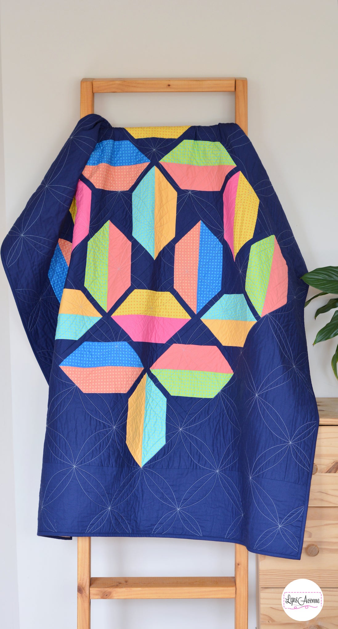 Flourishing Quilt pattern - a flower design quilt pattern in bright pink, yellow, blue and peach colour on a navy blue background