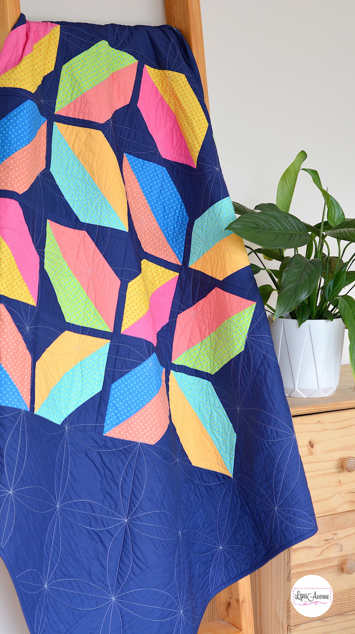 Flourishing Quilt pattern - a flower design quilt pattern in bright pink, yellow, blue and peach colour on a navy blue background