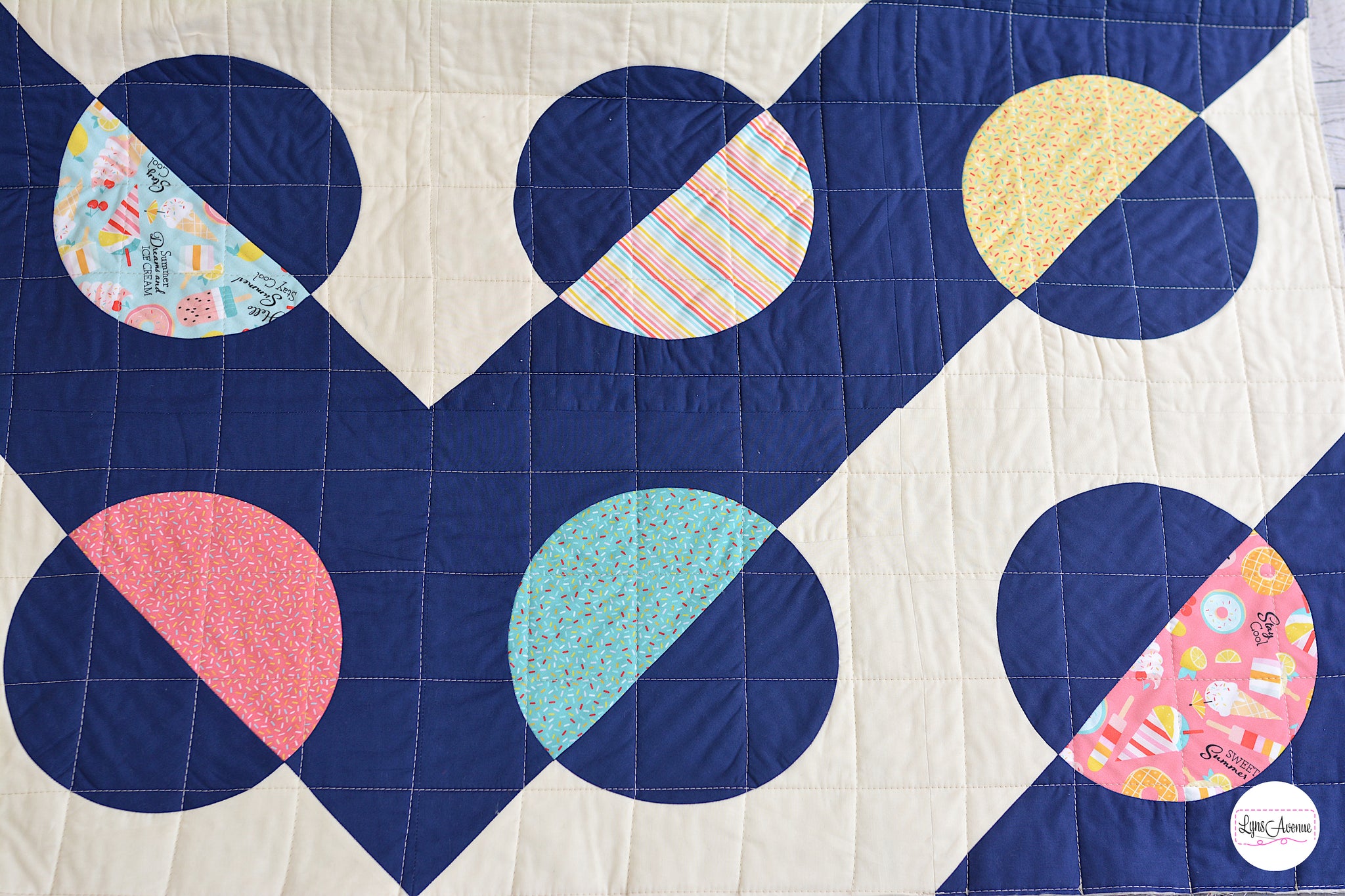 Hook and Pop quilt in navy blue and cream background with pops of colour in yellow, pink, green fabrics with sprinkles and ice cream designs