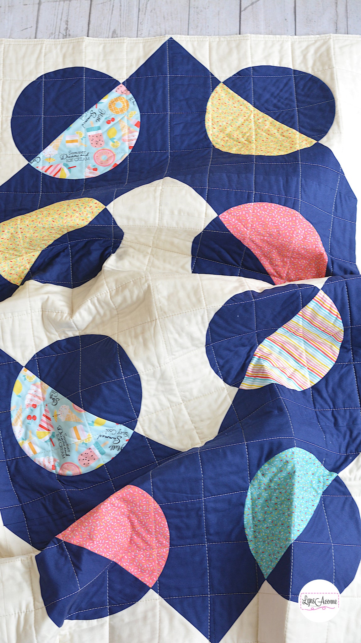 Hook and Pop quilt in navy blue and cream background with pops of colour in yellow, pink, green fabrics with sprinkles and ice cream designs