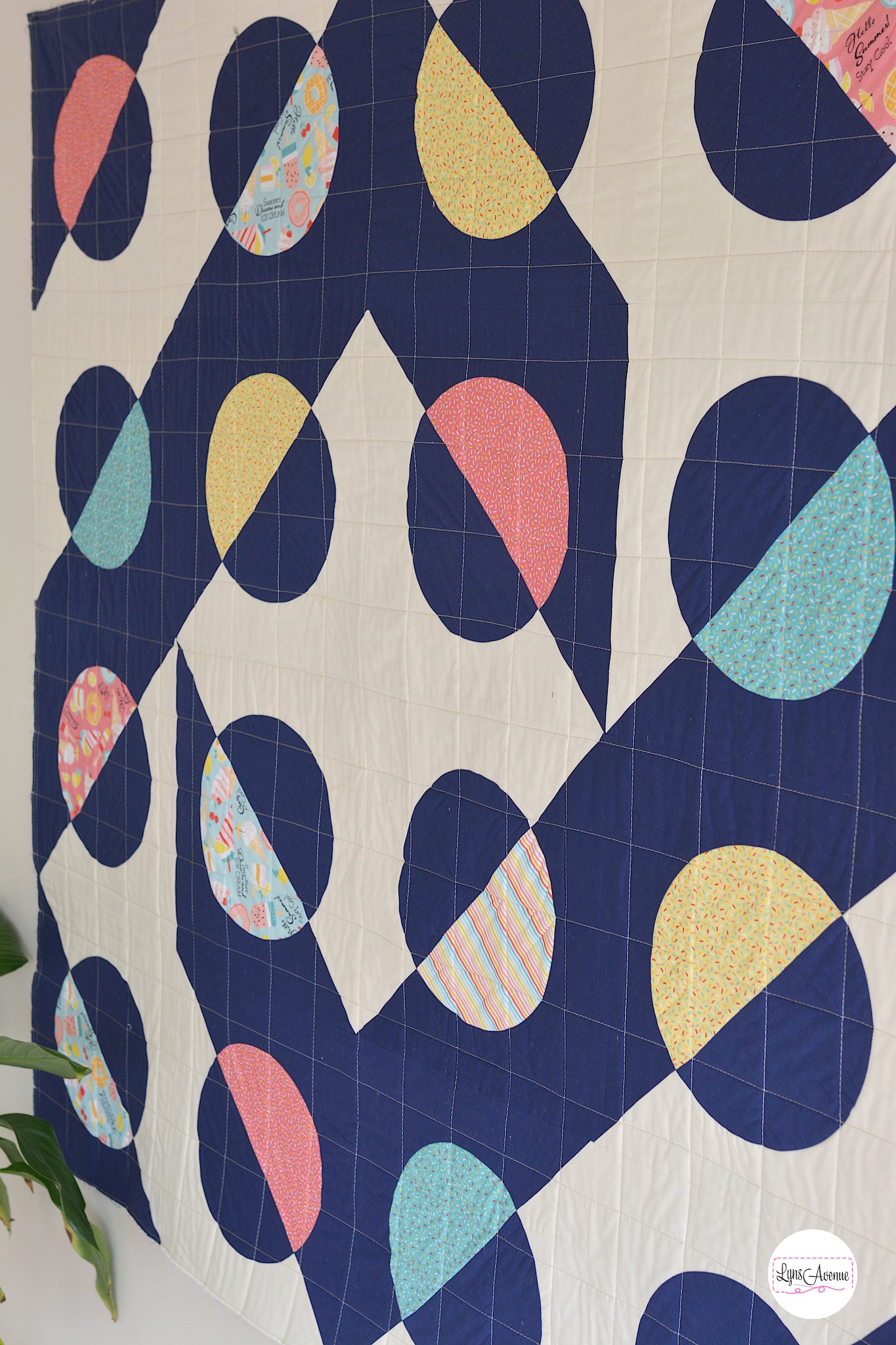 Hook and Pop quilt in navy blue and cream background with pops of colour in yellow, pink, green fabrics with sprinkles and ice cream designs