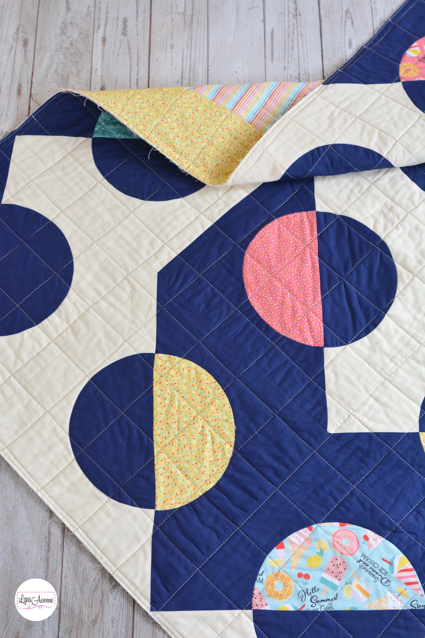 Hook and Pop quilt in navy blue and cream background with pops of colour in yellow, pink, green fabrics with sprinkles and ice cream designs