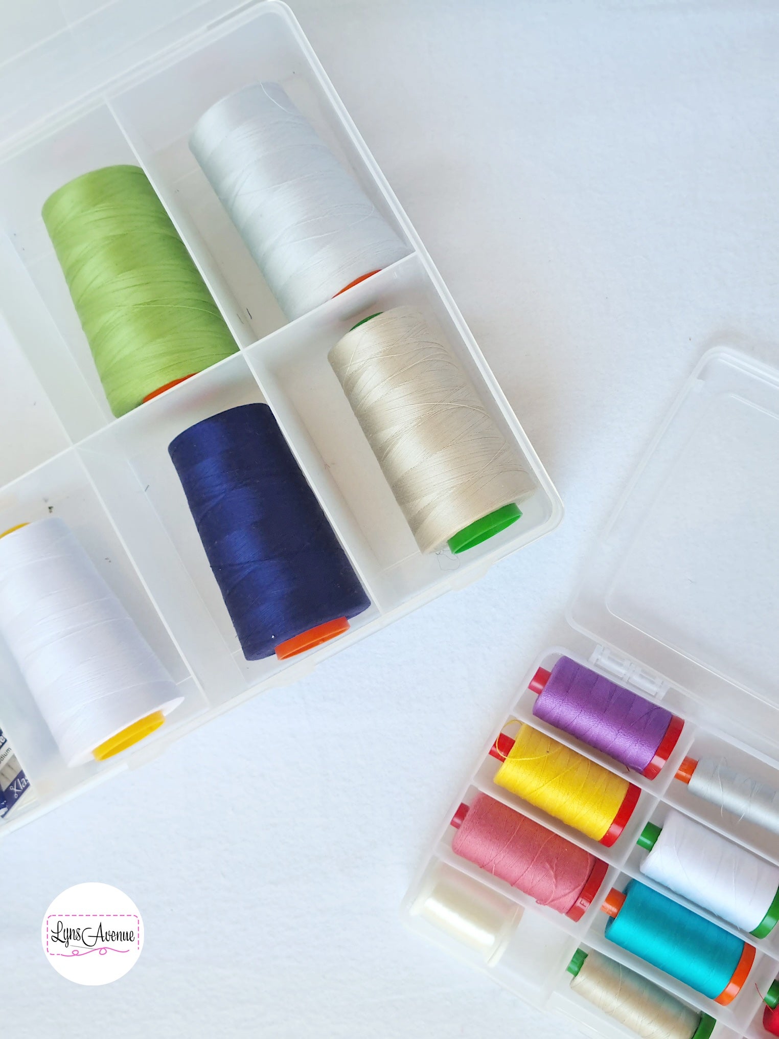 Picture of different coloured Aurifil threads in a plastic storage container with dividers