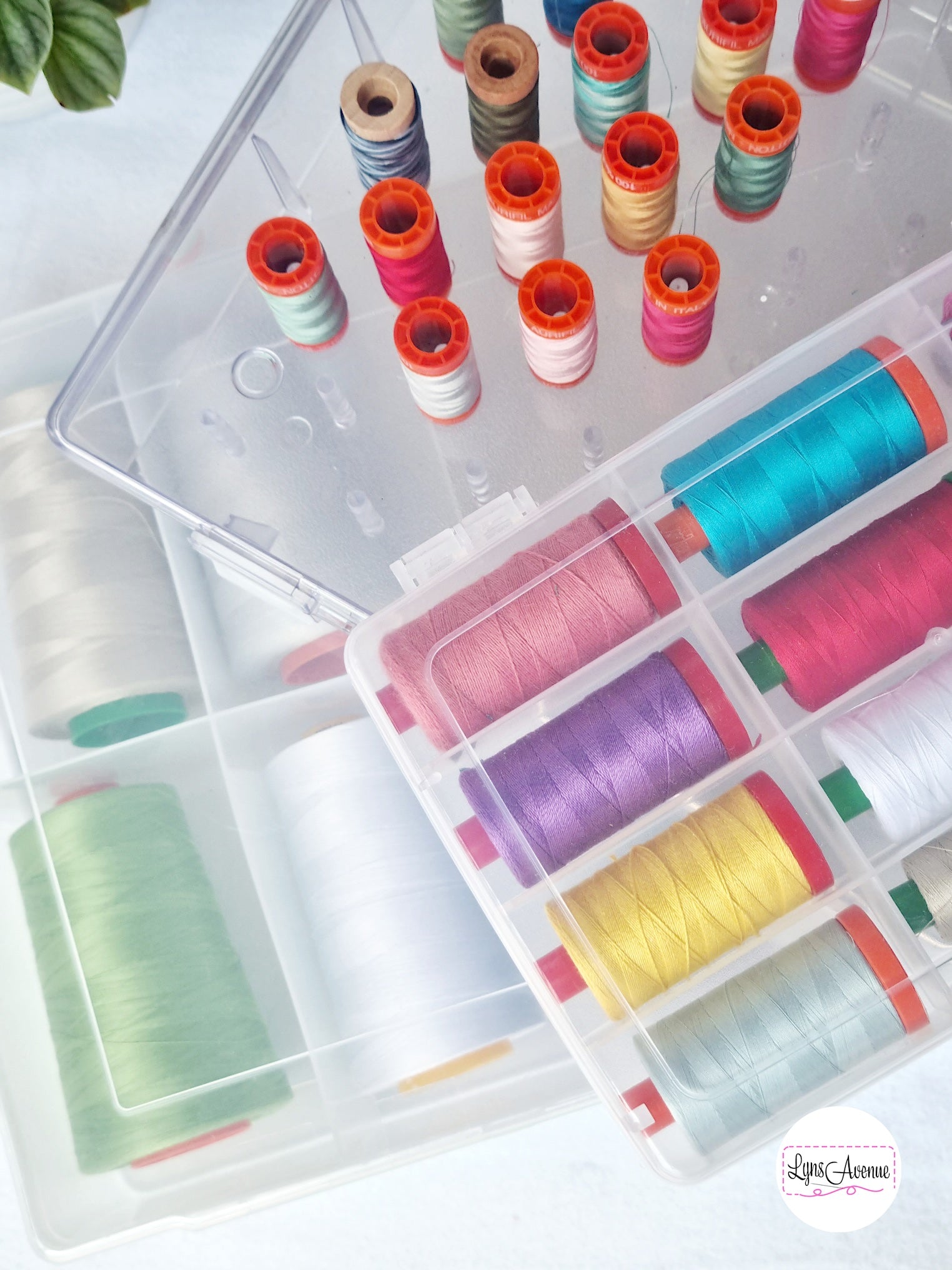 Picture of different coloured Aurifil threads in a plastic storage container with dividers