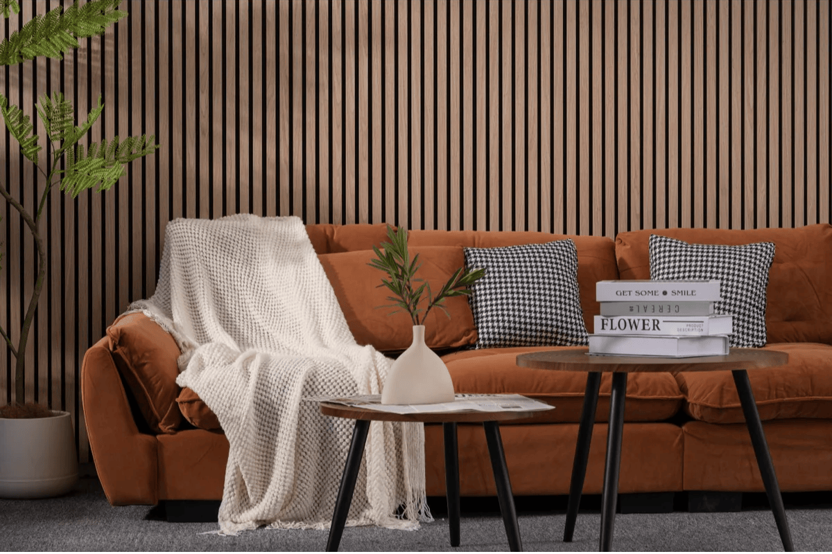 Terracotta armchair with white natural throw and two small wooden side tables against brown flute slat wall panel