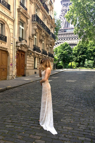 Bride standing in front of Eiffel Tower in backless lace wedding dress.