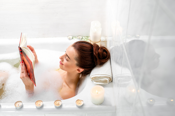 woman taking a bath while reading a book