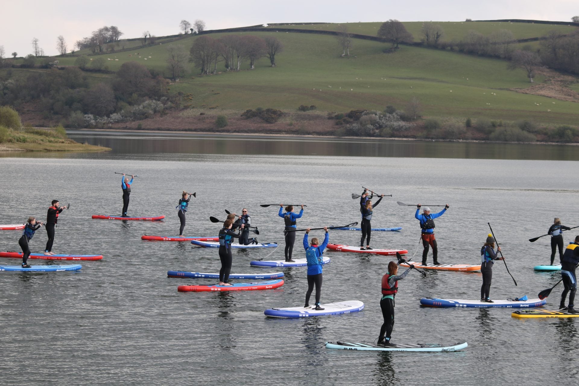 A group of people on Aquaplanet Paddle Boards holding paddles up