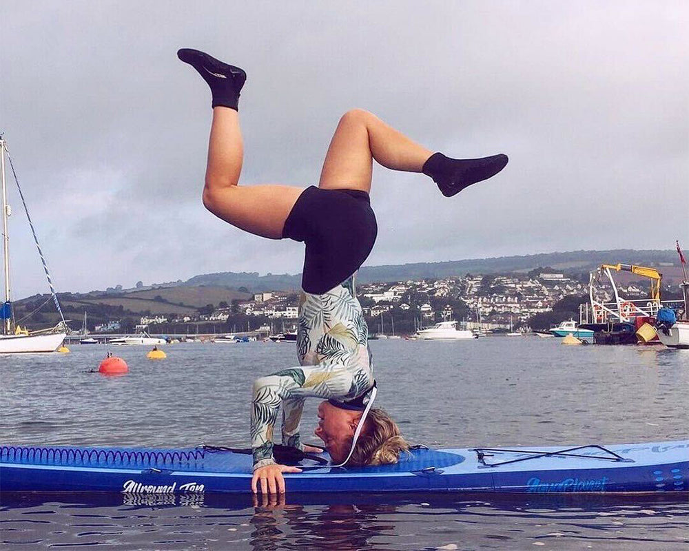 A woman on an Aquaplanet Allround Ten performing a headstand