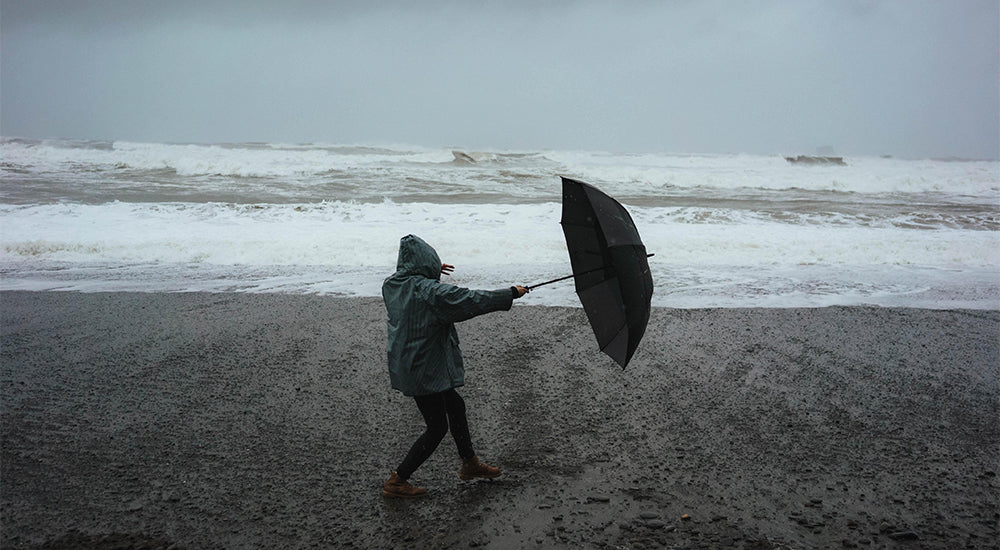Foto van iemand op een strand bij vreselijk weer