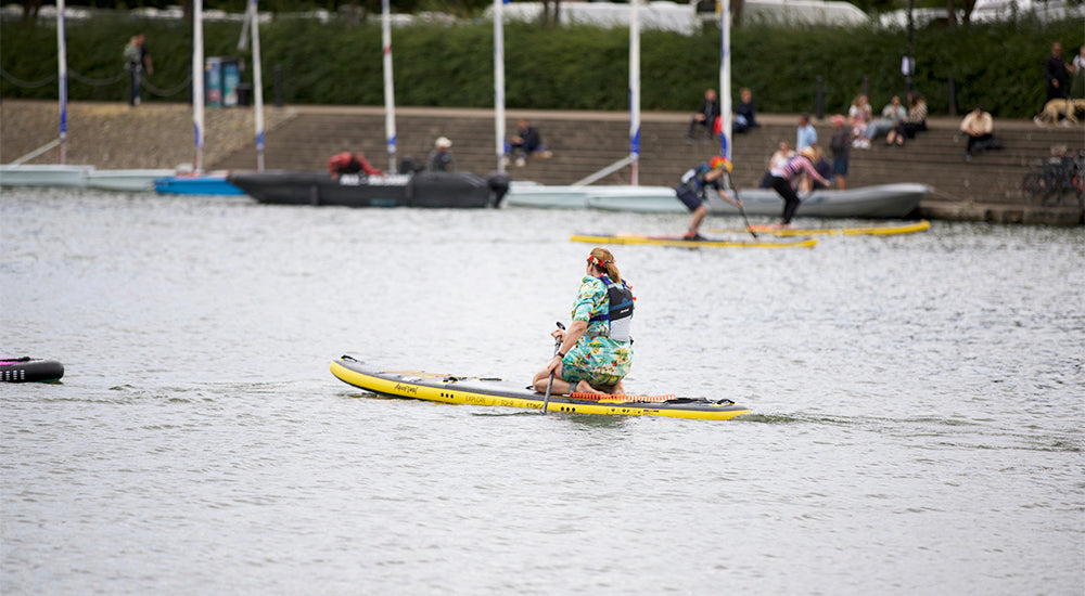 image of a person kneeling on an Aquaplanet paddle board