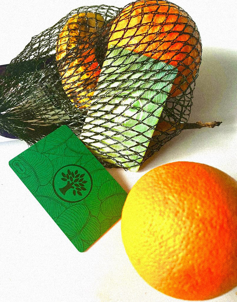 Two Green Wooden Digital Card with two Oranges fruit net a banana and another on a plain white background