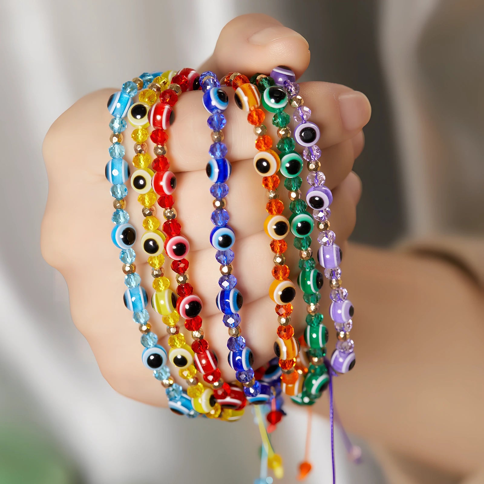 Adjustable crystal bead bracelet with blue eye design on braided rope, fits 15-19cm wrists