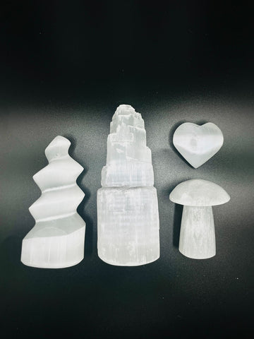 Selenite in forms like spiral tower, raw tower, mushroom and heart carvings as examples of the variations of Selenite for clearing and recharging